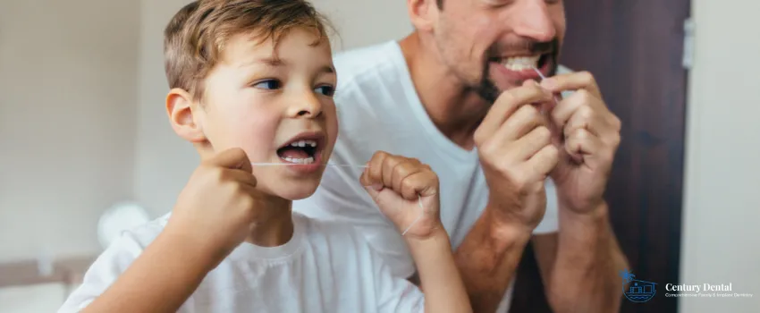 CD - Father and son flossing in front of a bathroom mirror