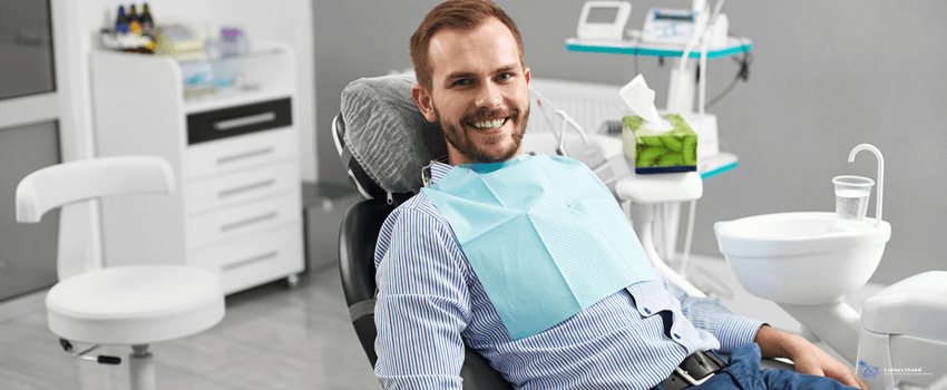 CD-Man is smiling to the camera while sitting in a dental chair